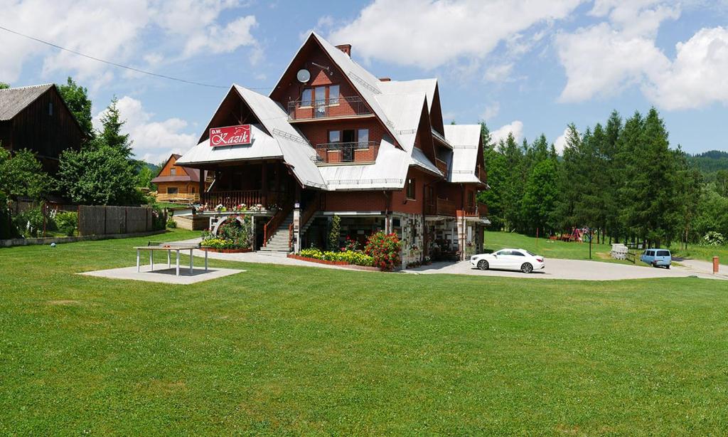 a large house with a car parked in front of it at Dom Wczasowy Kazik in Maniowy