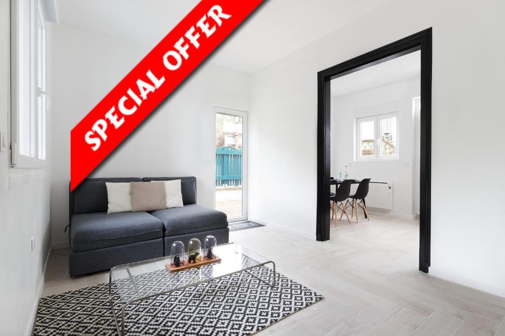 - un salon avec un canapé noir et un panneau rouge dans l'établissement SLEEPOO - Villa Boheme 7, à Trouville-sur-Mer