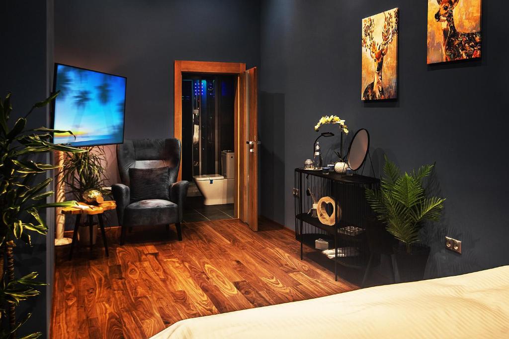 a bedroom with black walls and wooden floors and a bed at LOTUS LUXURY Apartments in Vranov nad Topľou