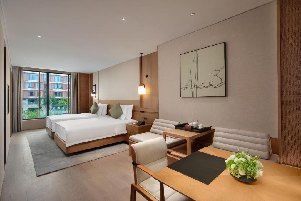 南京市にあるGrand WUJI Hotel, in The Unbound Collection by Hyattのベッドとリビングルームがあるホテルの部屋