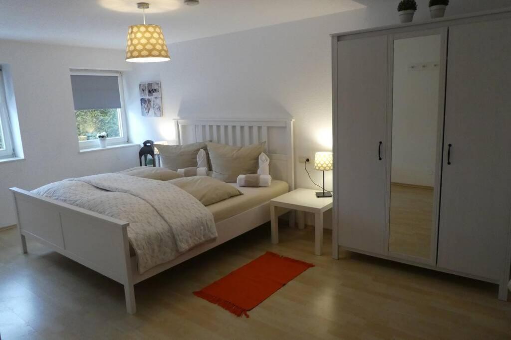 a white bedroom with a bed and a cabinet at Allgäutraum Ferienwohnung Nr 10 in Kempten