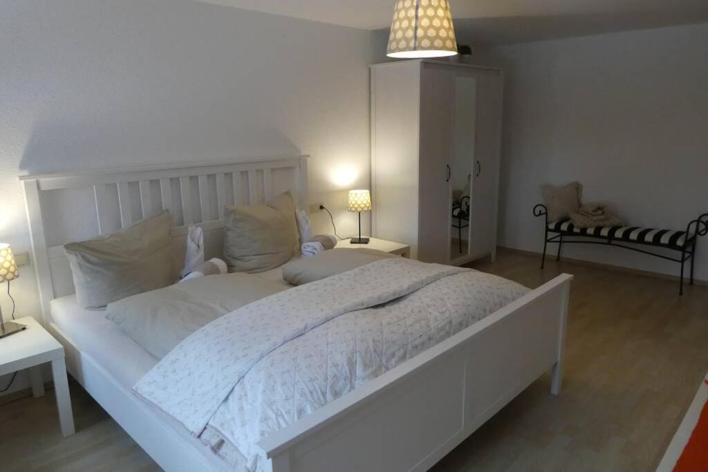 a bedroom with a large white bed with two lamps at Allgäutraum Ferienwohnung Nr 10 in Kempten