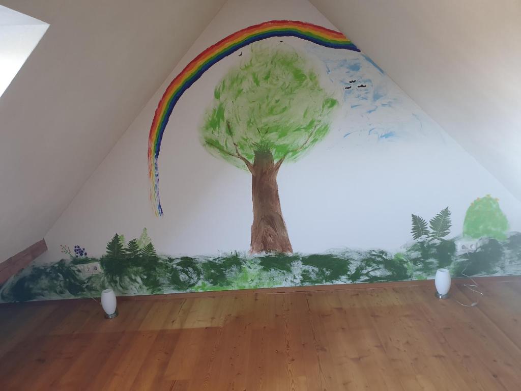 ein Bild eines Baumes und ein Regenbogen an der Wand in der Unterkunft Energetischer Urlaub in der Eifel in Germeter