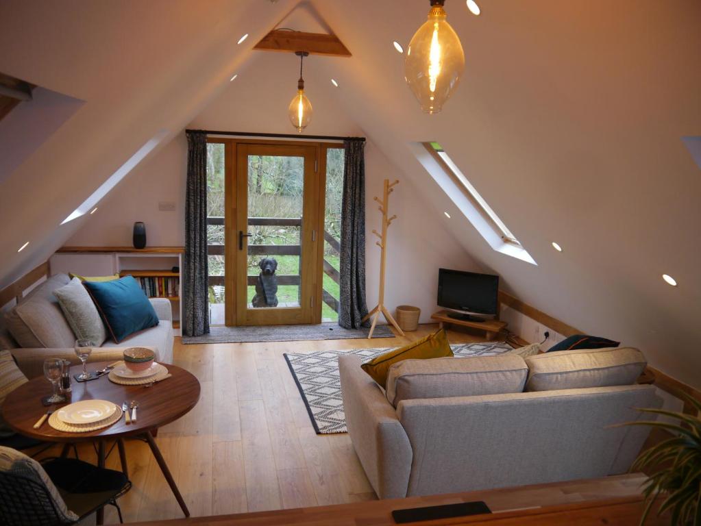 un soggiorno con divano e tavolo di The Studio @ Bridge Cottage a Totnes