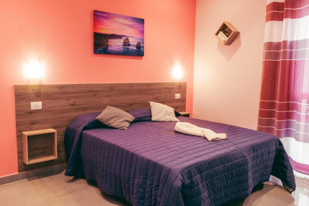 una camera con un letto e un piumone viola di Affittacamere Orchidea a Modena