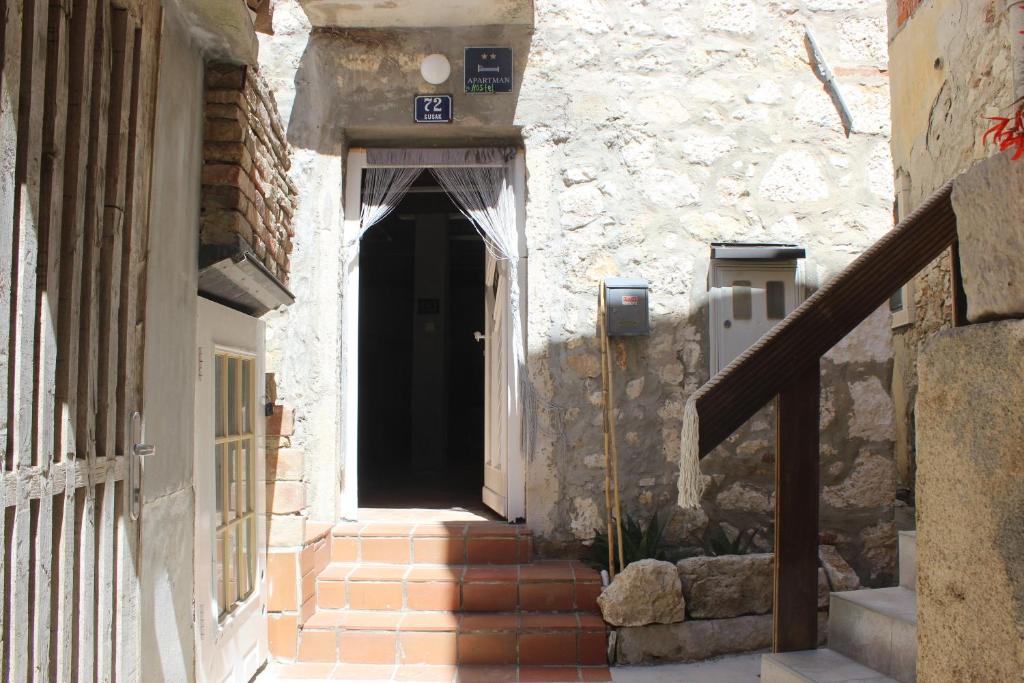 an entrance to a stone building with a black door at Heat Hostel in Susak