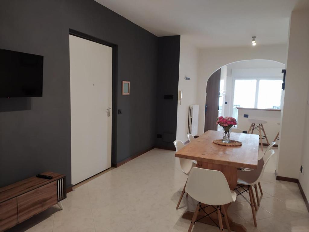 a dining room with a wooden table and white chairs at De Dominici's House in Castel di Sangro