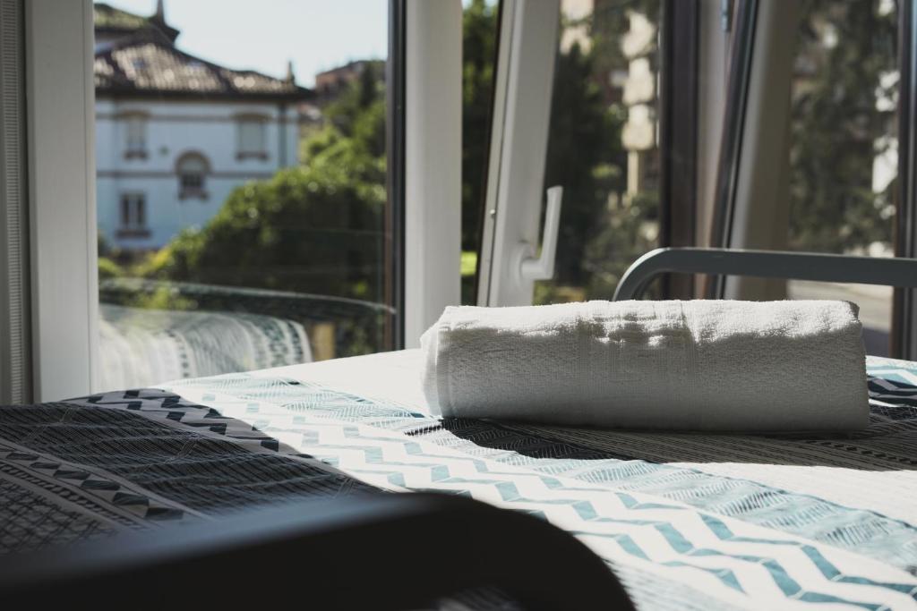 a white towel sitting on a table in front of a window at North SurfHouse in Gijón