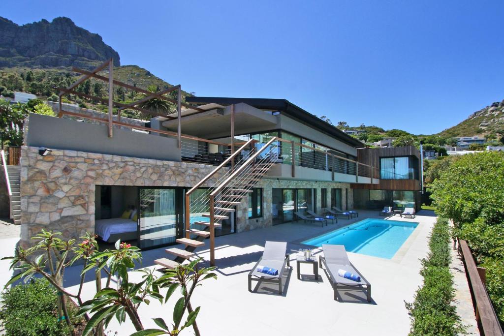 a villa with a swimming pool and a house at Villa Frangipani in Cape Town