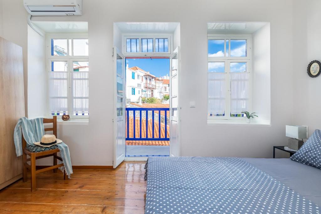 1 dormitorio con 1 cama y balcón en Niki's Traditional House, en Skopelos Town