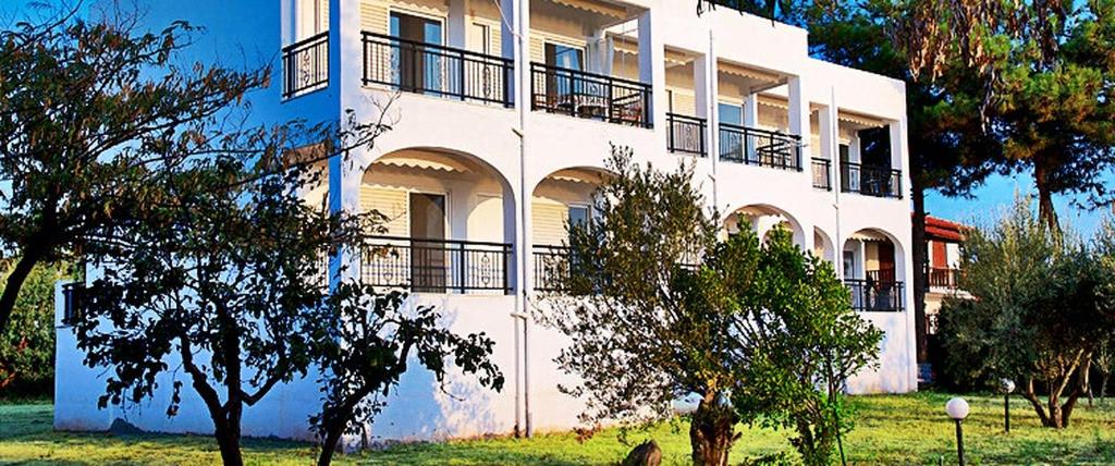 a white building with balconies on the side of it at VILLA MARAVGIA APARTMENT B in Akti Salonikiou