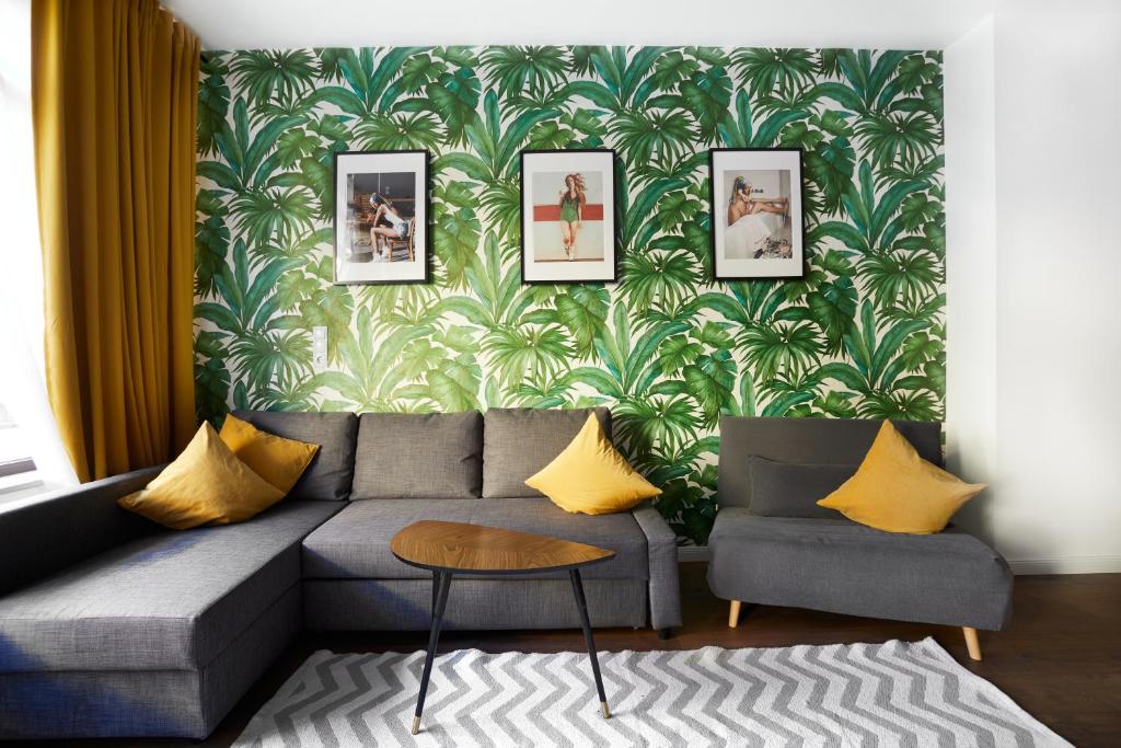 a living room with a gray couch and yellow pillows at Maria und Joseph Apartments in Innsbruck