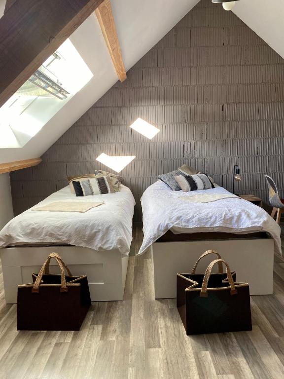 Cette chambre mansardée comprend 2 lits jumeaux. dans l'établissement Maison d'hôtes à la Ferme Une Pause à la Guette, à Uxeau