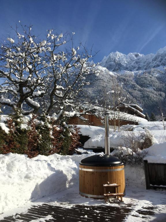 シャモニー・モンブランにあるChalet Plan Glacierの雪の中にベンチのある木製の温水浴槽