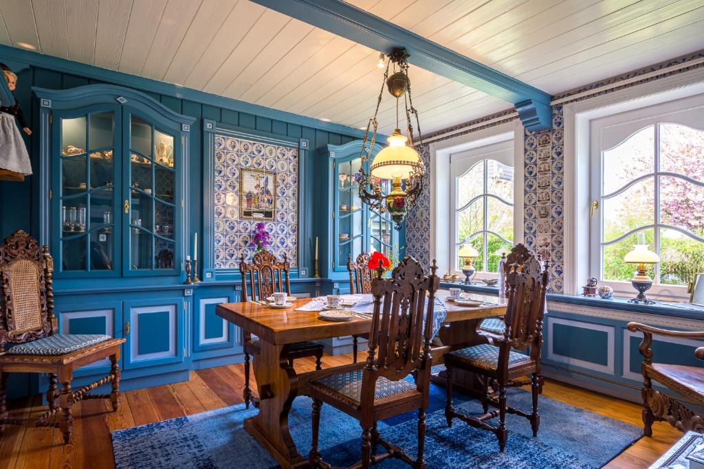 une salle à manger avec des murs bleus, une table et des chaises dans l'établissement Inselhotel Arfsten, à Wyk auf Föhr