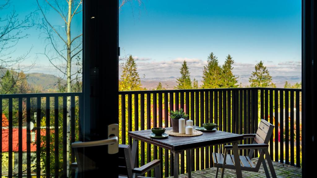 a table and chairs on a balcony with a view at HELLO Apartamenty przy strumyku in Karpacz