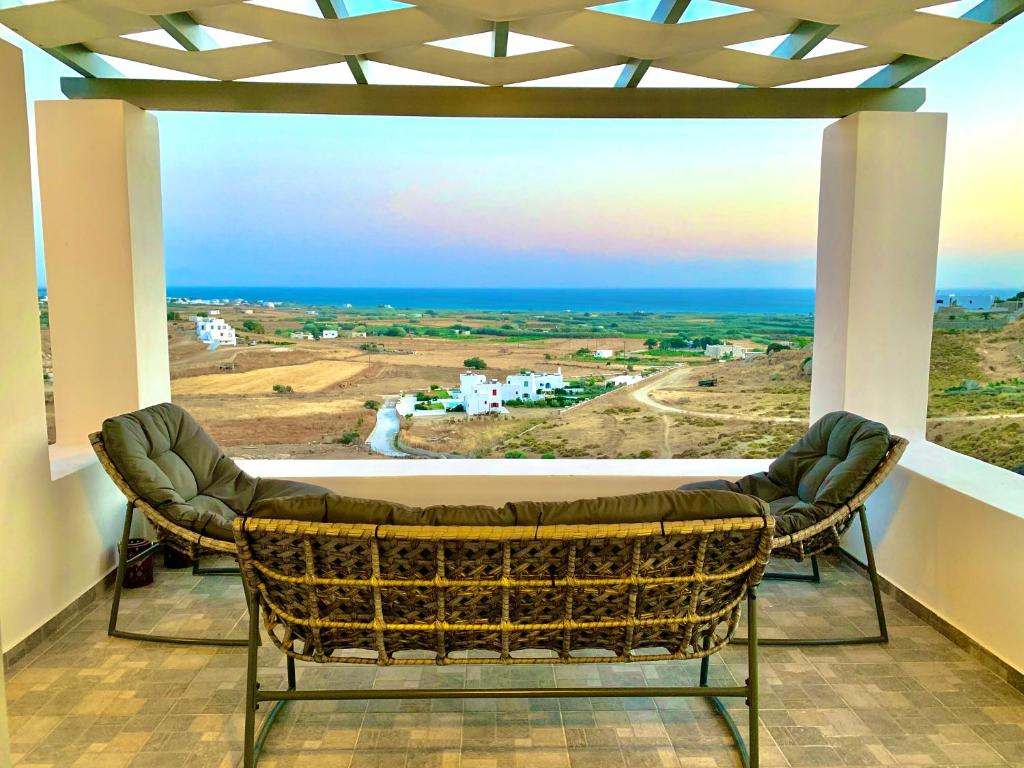 d'un balcon avec deux chaises et une vue sur l'océan. dans l'établissement house on the rock, à Mikri Vigla