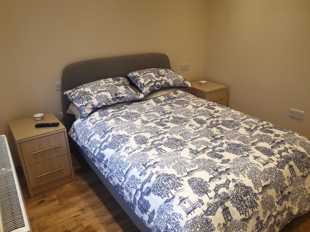 a bedroom with a bed and two night stands at London Luxury Apartments 4 min walk from Ilford Station, with FREE PARKING FREE WIFI in Ilford