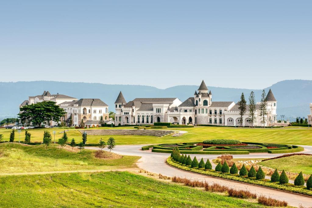 a large white mansion with a road leading to it at Mövenpick Resort Khao Yai in Ban Wang Sai