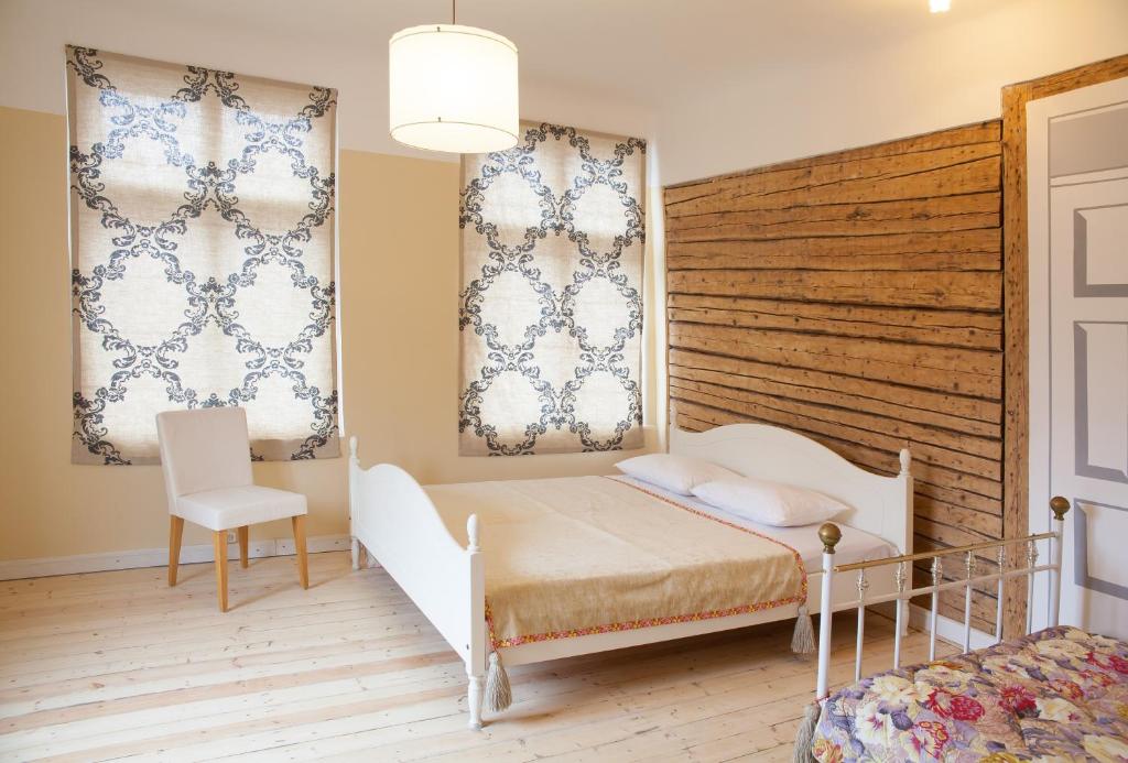 1 dormitorio con 1 cama, 1 silla y 2 ventanas en Aia Guest Apartment, en Pärnu