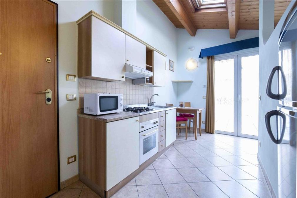 kuchnia z białymi szafkami i mikrofalówką w obiekcie Residenza Melucci w Rimini