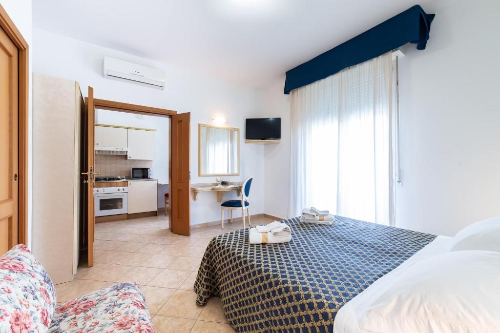 pokój hotelowy z łóżkiem i kuchnią w obiekcie Residenza Melucci w Rimini