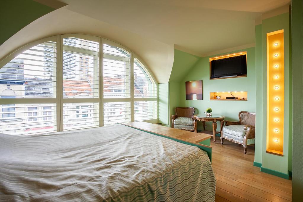 een slaapkamer met een groot bed en een groot raam bij Thai Time Wellness in Antwerpen