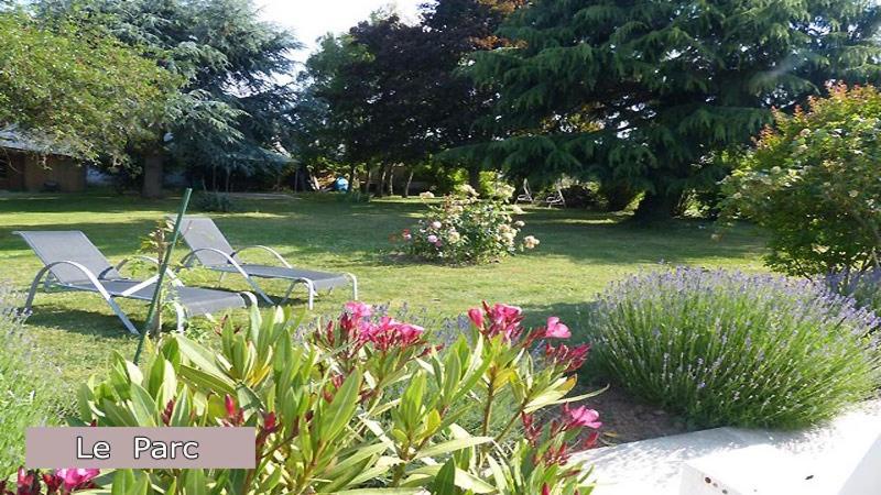 zwei Stühle in einem Garten mit Blumen und Pflanzen in der Unterkunft Le Clos Fleuri in Vineuil