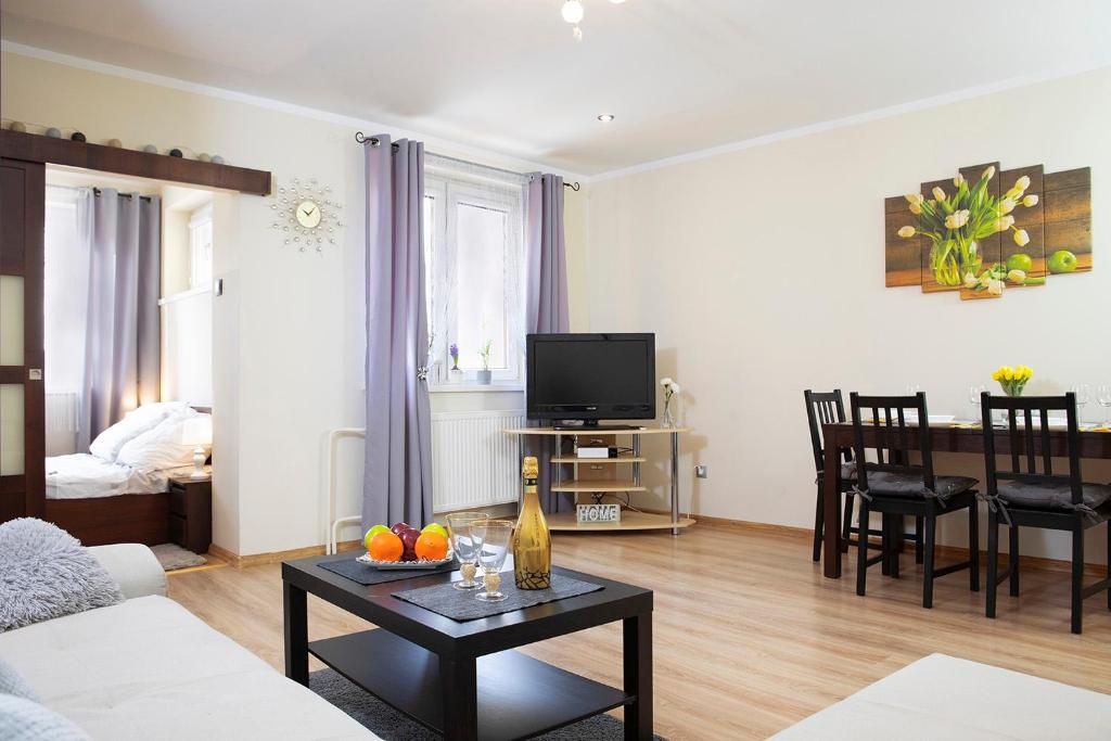 ein Wohnzimmer mit einem Sofa und einem Tisch in der Unterkunft Luxus Apartament Wzgorze in Gdynia