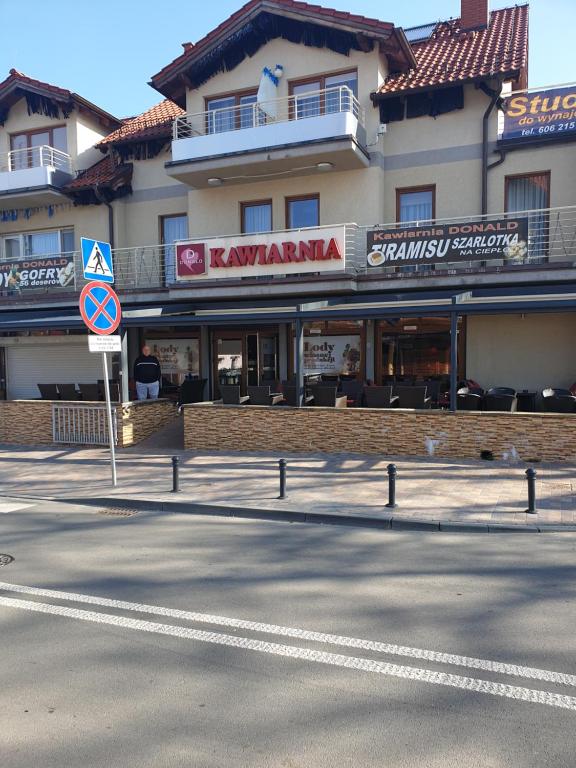 a building on the side of a street with a street sign at Apartamenty Donald in Krynica Morska