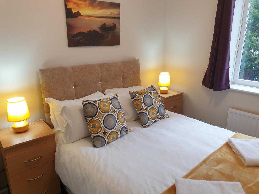 a bedroom with a bed with pillows and two lamps at South Shield's Diamond 3 Bedroom House Sleeps 6 Guests in South Shields