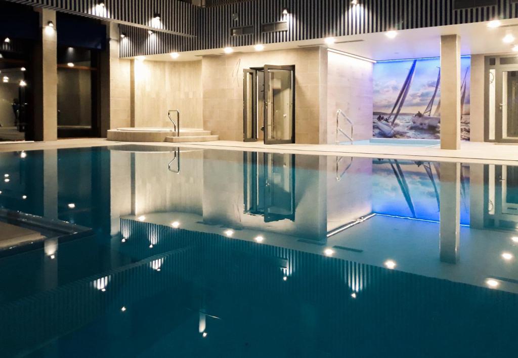 uma casa de banho com uma piscina com um lavatório em Port Bogaczewo Hotel & SPA em Giżycko