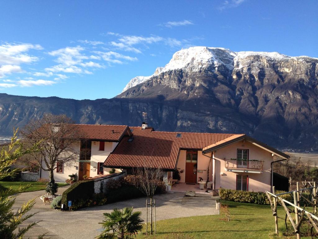 a house with a mountain in the background at Agriturismo Maso Grener in Lavis