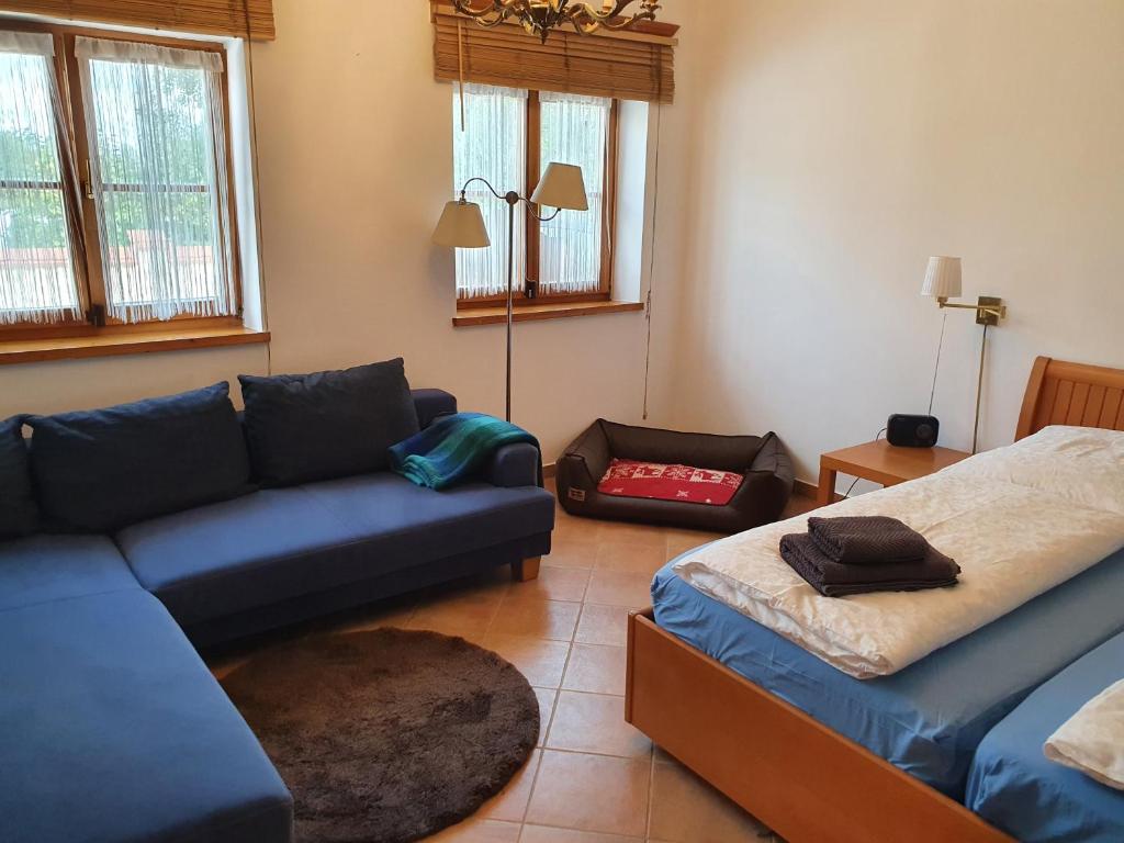 a living room with a couch and a bed at Landhaus Steirerengel - Ferien &amp; Jagd in Lócs