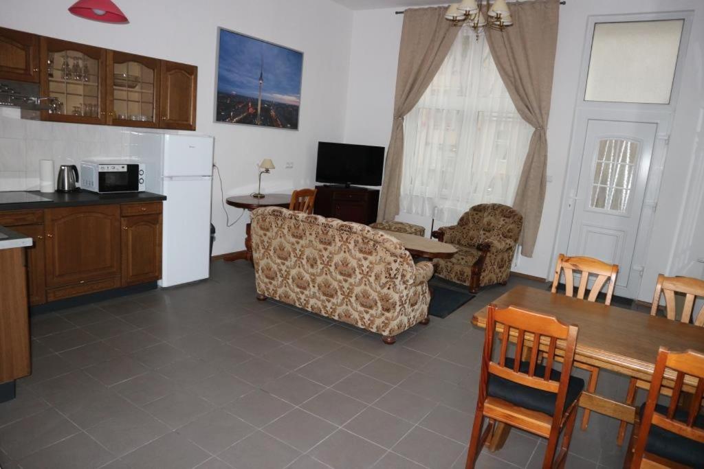 a kitchen and living room with a couch and a table at Holiday Home Roy in Berlin