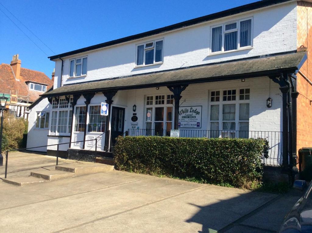 un edificio blanco con un cartel delante en White Lodge Guest House, en Skegness