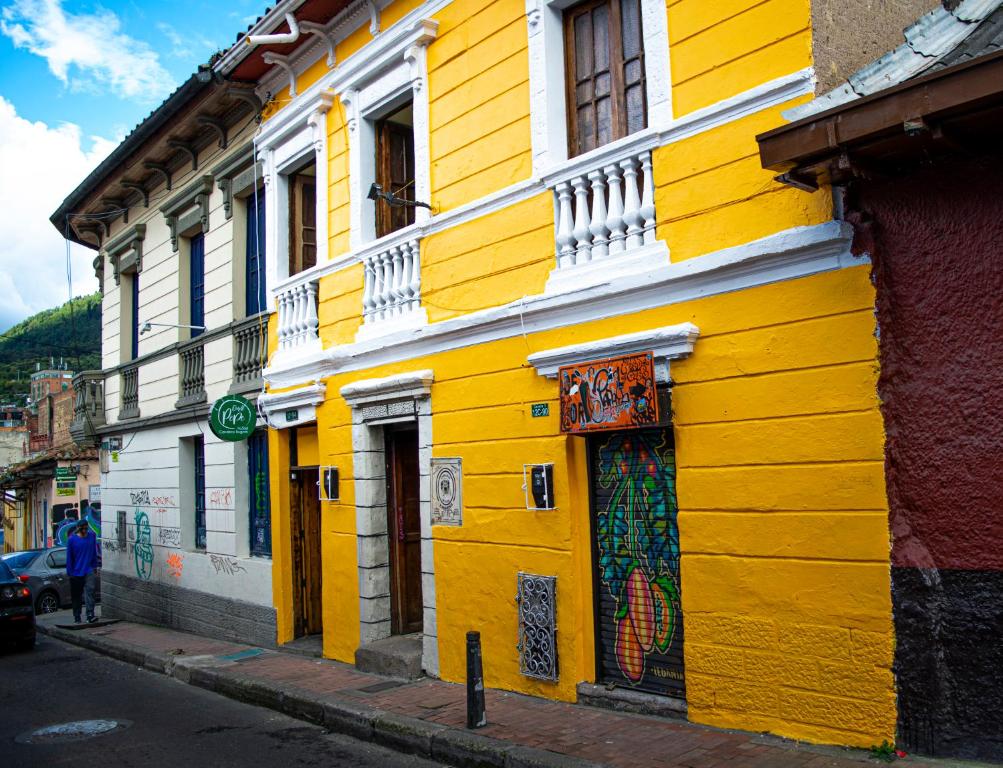 een geel gebouw aan de straatkant bij Onde Pepe Hostel in Bogota