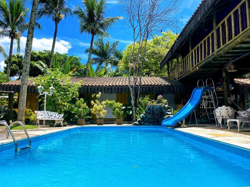 a swimming pool with a slide in a resort at Pousada Papaya Container in Ubatuba
