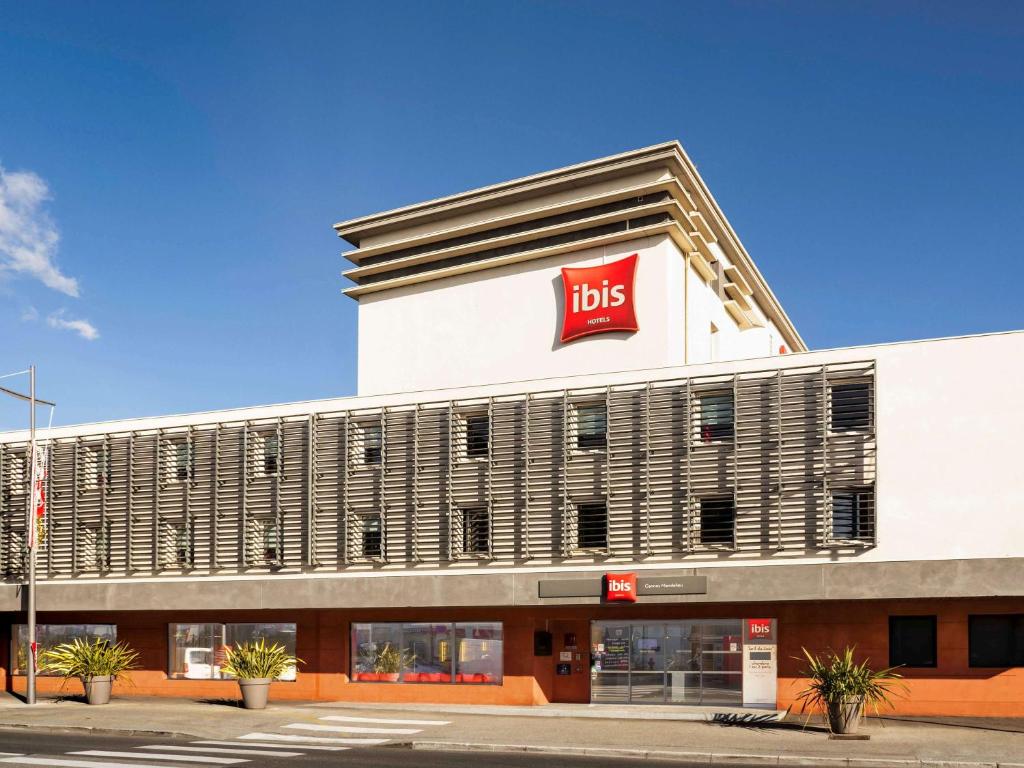 un edificio de tiendas con un letrero de alta en ibis Cannes Mandelieu, en Mandelieu-la-Napoule