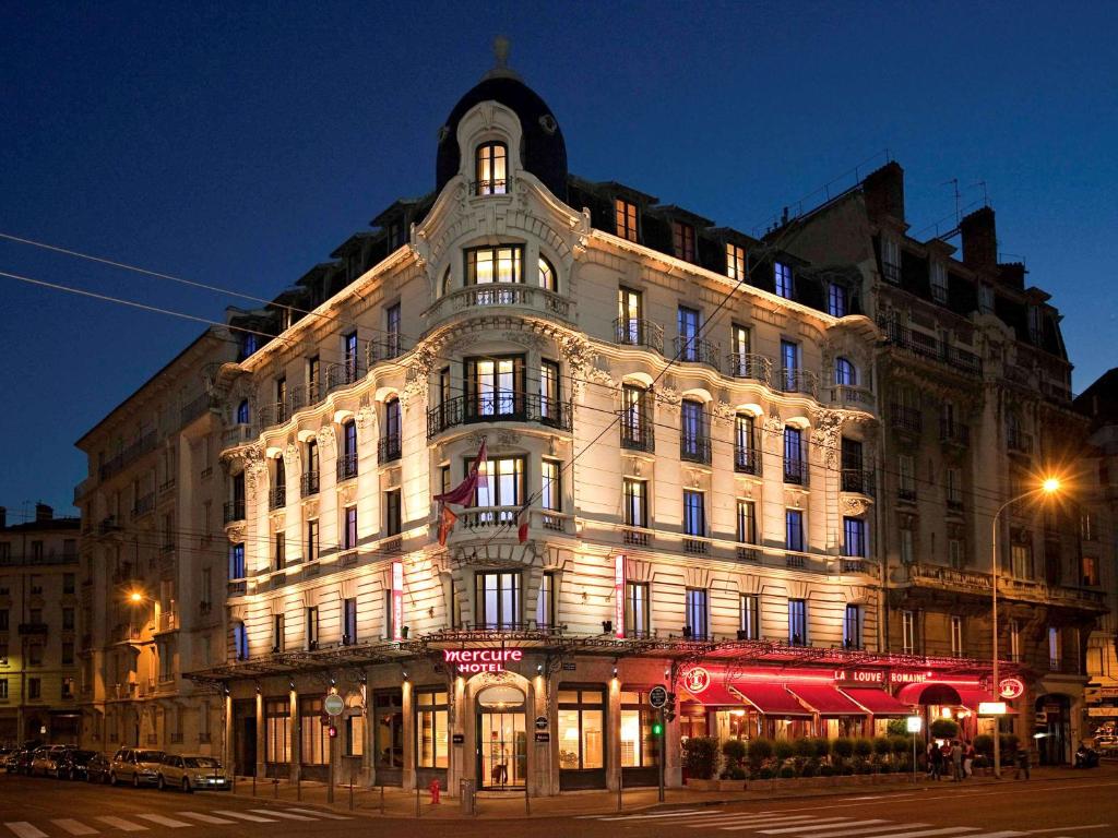 a large building on the corner of a street at night at Mercure Lyon Centre Brotteaux in Lyon