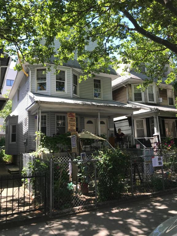 dom z osobą siedzącą na ganku w obiekcie CLASSICAL AMERICAN Homestay HOUSE w mieście Brooklyn