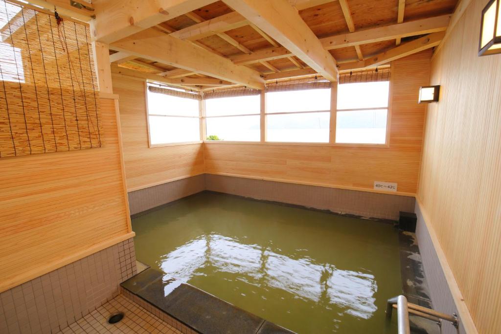 
a bath room with a tub and a window at Toya-onsen Hotel Hanabi in Lake Toya
