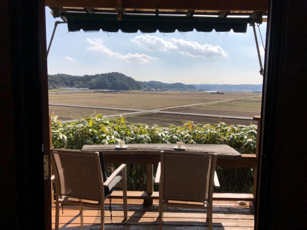 a table and chairs on a porch with a view at 南房総 貸切コテージ セントシュバイン in Minamiboso