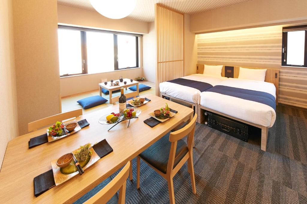 a hotel room with a bed and a desk and a table at MONday Apart Premium Ginza Shintomicho in Tokyo