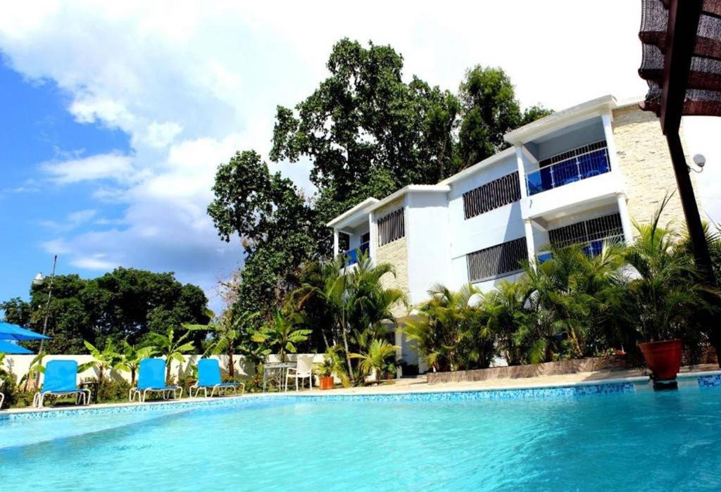 un hotel con piscina frente a un edificio en Cozy 2br-2bt Apt Near The Beach And Main Street, en Sosúa