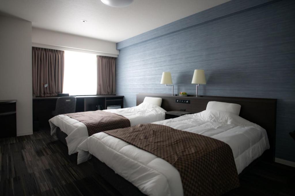 Rúm í herbergi á Sakura Shimanami Hotel