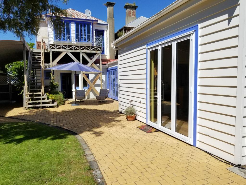 une maison avec des portes coulissantes en verre et une terrasse dans l'établissement City central apartment – modern, private & quiet, à Invercargill