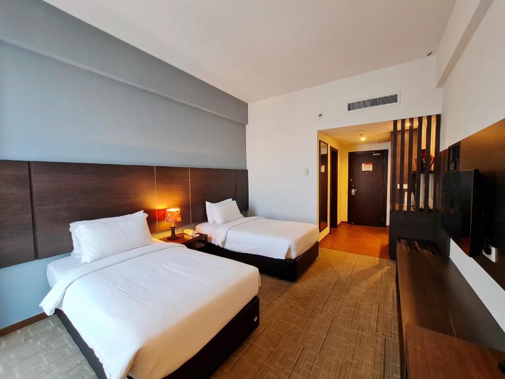 een hotelkamer met 2 bedden en een televisie bij Swan Garden Hotel in Melaka