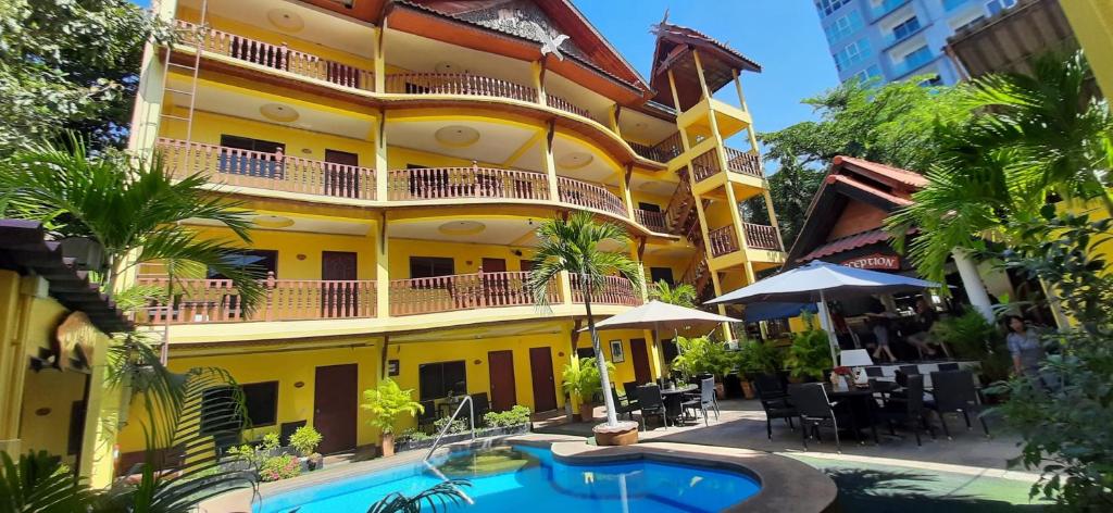 un hôtel avec une piscine en face d'un bâtiment dans l'établissement Phratamnak Inn - 100 meter from Beach, à Pattaya (sud)