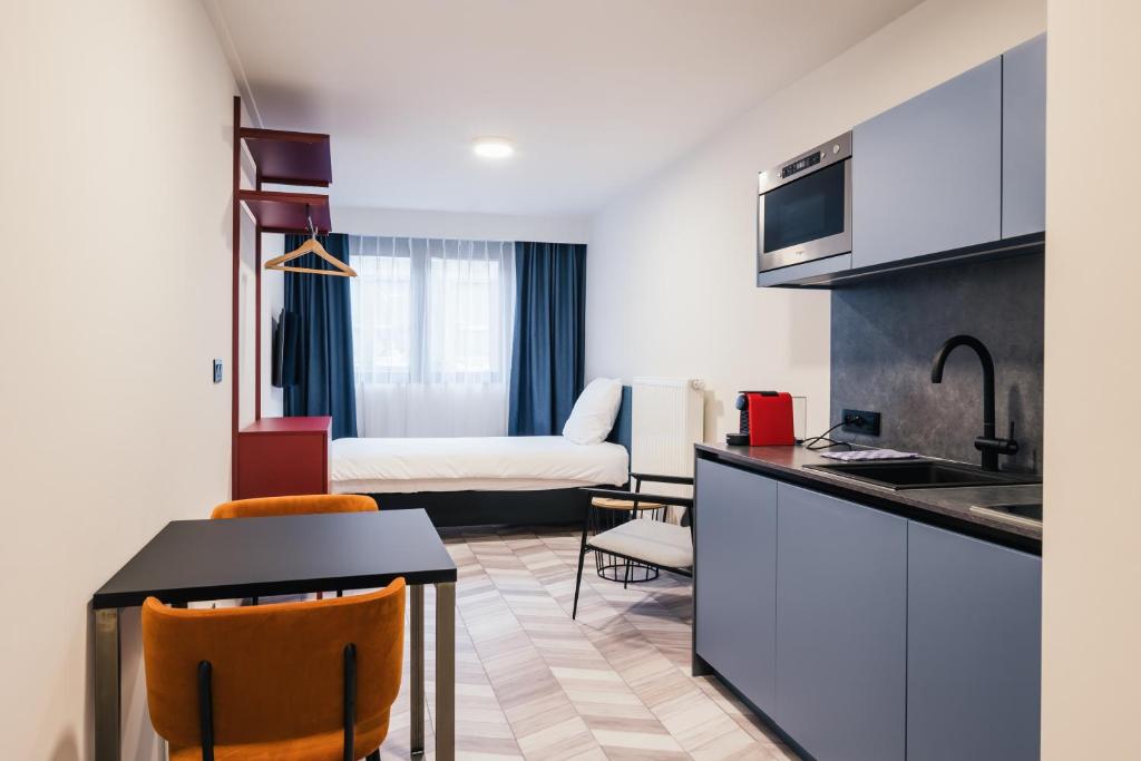 una cucina e un soggiorno con un letto in una camera di ROXI Residence Gent a Gand